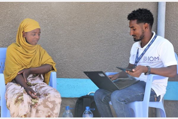 A young female migrant sits with an IOM MRP support staff at the Migrant Response Centre opened in 2023, in Dewelle Ethiopia. Photo: Eva Sibanda/IOM2023.